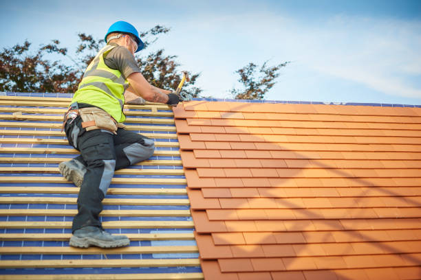 clay plain tiled roof installation a roofer nails on the roof tiles Roof Repair stock pictures, royalty-free photos & images